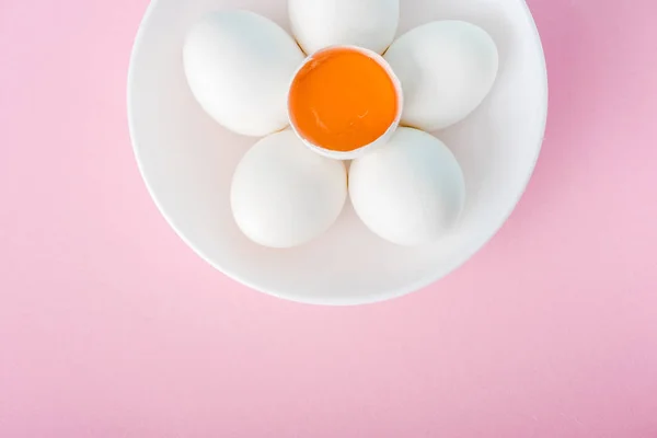 Vue du dessus de l'assiette avec fleur faite d'oeufs et jaune d'oeuf sur rose avec espace de copie — Photo de stock