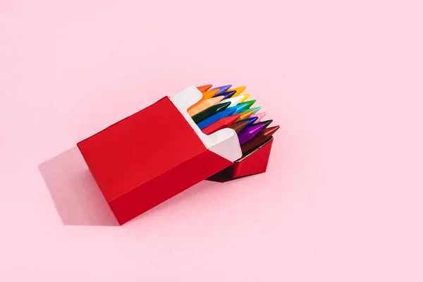 Multicolored crayons in cigarette pack on pink with copy space, smoking concept — Stock Photo