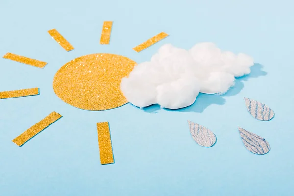 Sol de papel brillante y algodón caramelo nube con gotas de lluvia de plata en azul - foto de stock