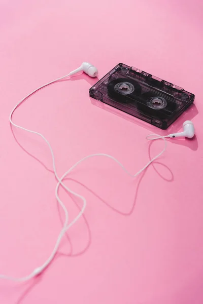 Casete de audio vintage de plástico con auriculares en rosa, concepto de música - foto de stock