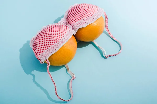 Бюстгальтер с двумя апельсинами на синий, груди концепции — стоковое фото