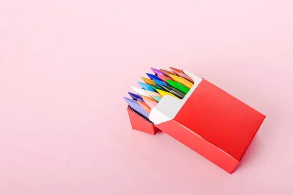 Crayons colorés en paquet de cigarettes sur rose avec espace de copie, concept fumeur — Photo de stock