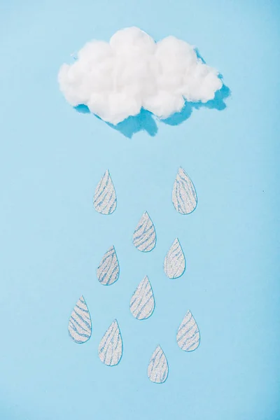 Вид зверху на хмару з бавовняними цукерками з блискучими краплями на синьому — стокове фото