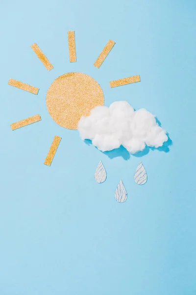 Papier Sonne und Zuckerwatte Wolke mit glitzernden Regentropfen auf blau — Stockfoto