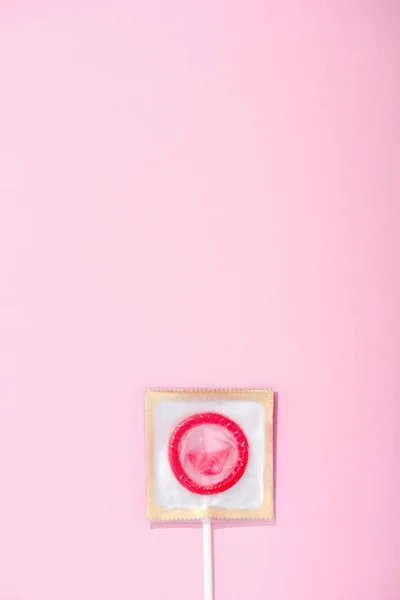 Top view of condom wrapped as lollipop on pink with copy space, Safe Sex concept — Stock Photo