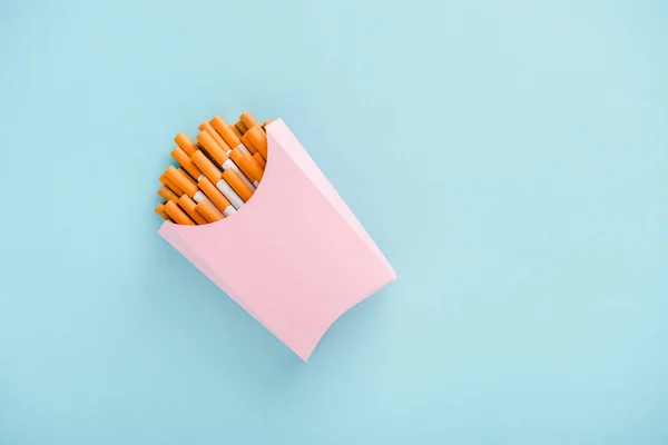 Vista dall'alto di sigarette confezionate in scatola di carta isolata su blu con spazio copia, concetto di patatine fritte — Foto stock