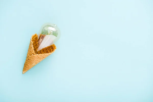 Vista dall'alto lampadina di vetro in cono gelato isolato su blu con spazio copia — Foto stock