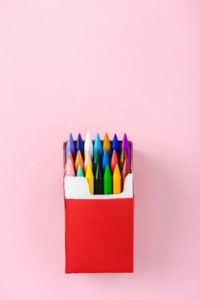 Vista superior de lápices de colores multicolores en paquete de cigarrillos rojos en rosa con espacio para copiar, concepto de fumar - foto de stock