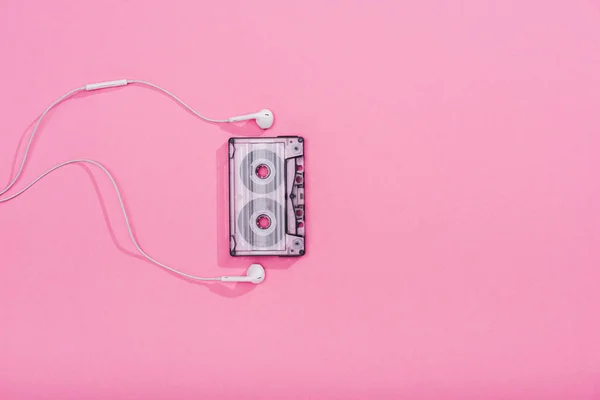 Vista superior de casete de audio vintage con auriculares en rosa con espacio para copiar - foto de stock