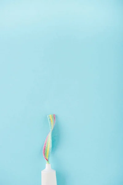 Top view of toothpaste tube with chewing candy isolated on blue with copy space — Stock Photo