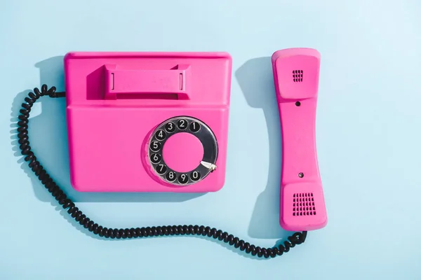 Vista superior del teléfono de línea vintage púrpura en azul - foto de stock