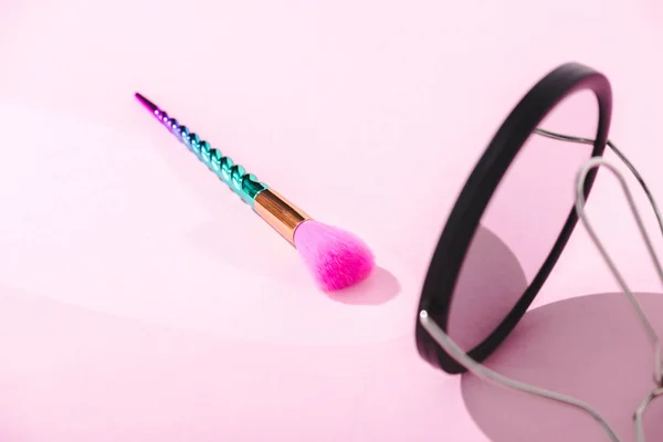 Selective focus of colorful makeup brush with mirror on pink — Stock Photo