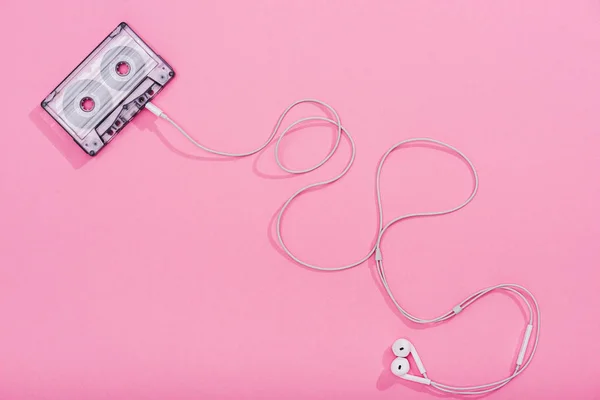 Vista superior de casete de audio vintage con auriculares en rosa, concepto de música - foto de stock