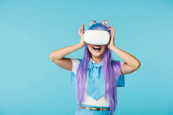 Muchacha de anime sonriente en peluca púrpura y auriculares vr aislados en azul - foto de stock