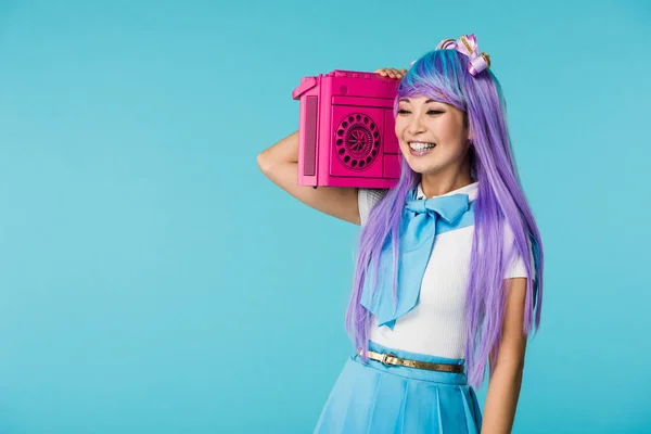 Lächelndes asiatisches Otaku-Mädchen mit lila Perücke und Boombox auf blauem Grund — Stockfoto