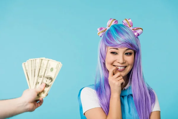 Vue recadrée de l'homme tenant des billets en dollars et coûteux asiatique anime fille isolé sur bleu — Photo de stock