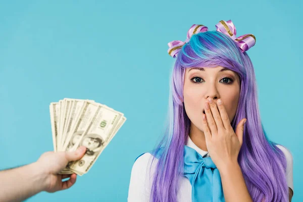 Recortado vista de hombre celebración dólar billetes y sorprendido asiático anime chica aislado en azul - foto de stock