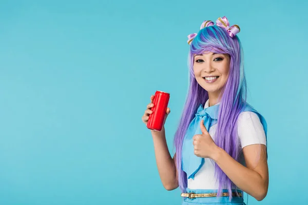 Усміхнена азіатська дівчина аніме у вігві тримається може з напоєм ізольовано на синьому — стокове фото
