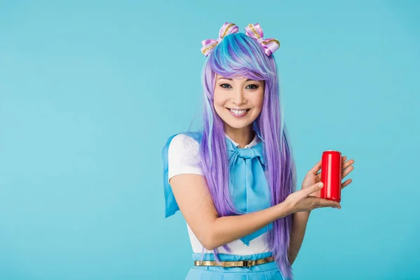 Sorrindo asiático anime menina no peruca segurando lata com bebida isolada no azul — Fotografia de Stock