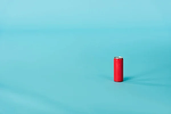 Boîte en aluminium rouge avec boisson sur la surface bleue — Photo de stock