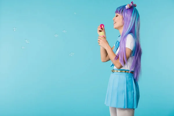 Side view of anime girl with soap bubbles isolated on blue — Stock Photo