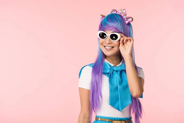 Chica de anime sonriente en peluca y gafas de sol aisladas en rosa - foto de stock