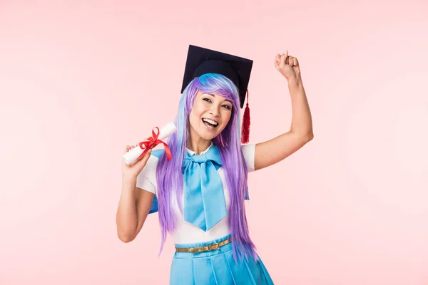 Asian anime girl in academic cap holding diploma and dancing isolated on pink — Stock Photo