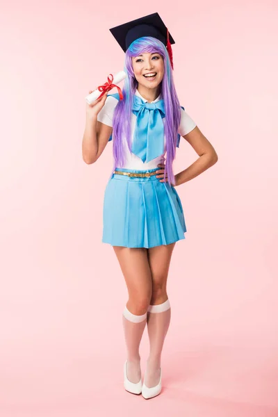 Full length view of asian anime girl in academic cap holding diploma on pink — Stock Photo