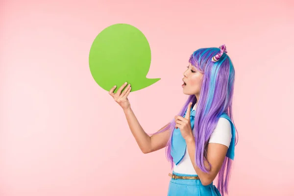 Ásia anime menina segurando verde discurso bolha e mostrando ideia sinal no rosa — Fotografia de Stock