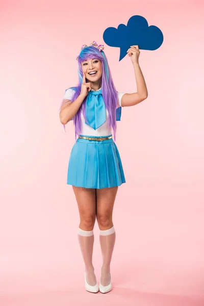 Largura completa vista de riendo asiático anime chica en peluca celebración pensamiento burbuja en rosa - foto de stock