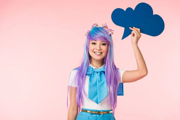 Sonriendo asiático anime chica holding pensamiento burbuja en rosa - foto de stock