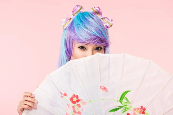 Anime asiático chica en peluca celebración papel paraguas aislado en rosa - foto de stock