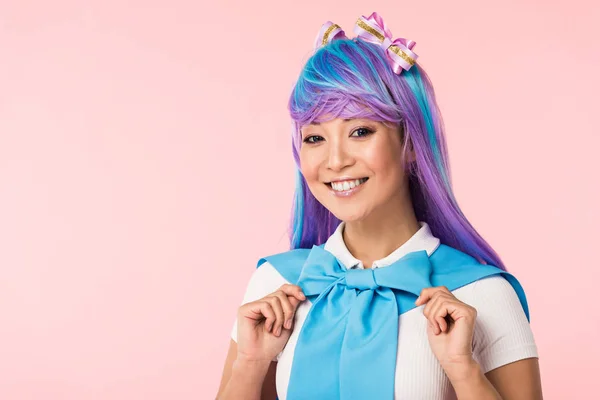 Smiling otaku girl in purple wig looking at camera isolated on pink — Stock Photo