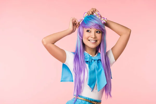 Улыбающаяся азиатка отаку в фиолетовом парике, стоящая на розовом — стоковое фото