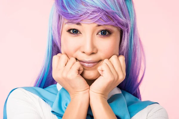 Sonriente asiático anime chica en peluca posando aislado en rosa - foto de stock