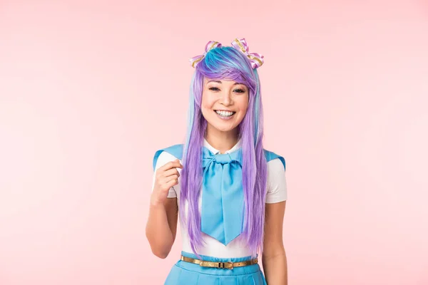 Glücklich asiatische anime Mädchen in lila Perücke lächelnd auf rosa — Stockfoto