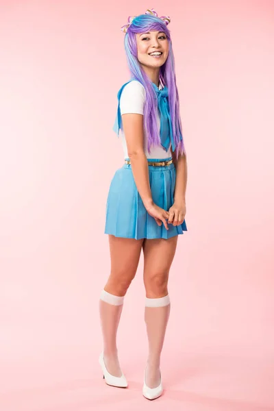 Full length view of otaku girl in purple wig smiling on pink — Stock Photo