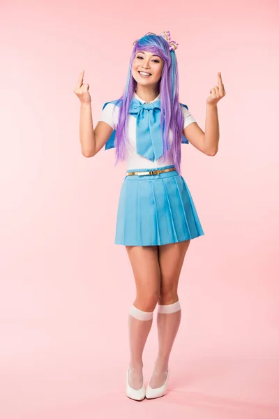 Comprimento total vista de sorrir asiático anime menina mostrando médio dedos em rosa — Fotografia de Stock
