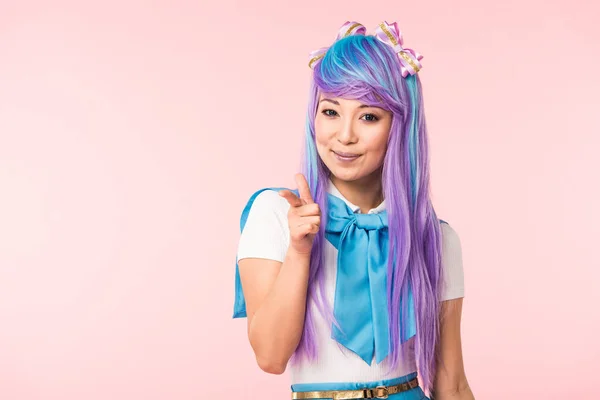 Sourire asiatique anime fille pointng avec doigt isolé sur rose — Photo de stock