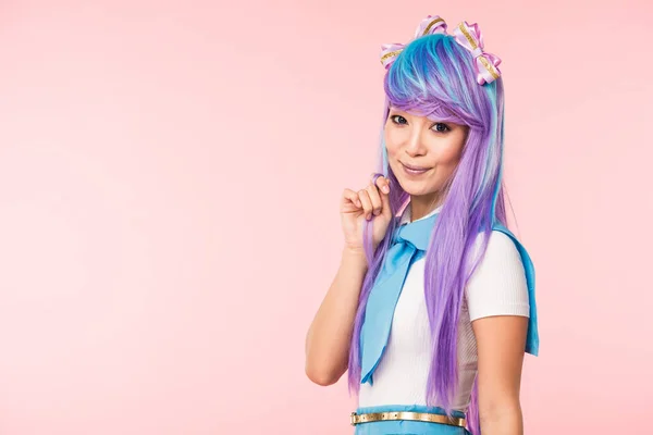 Schöne asiatische anime Mädchen in lila Perücke Blick auf Kamera isoliert auf rosa — Stockfoto