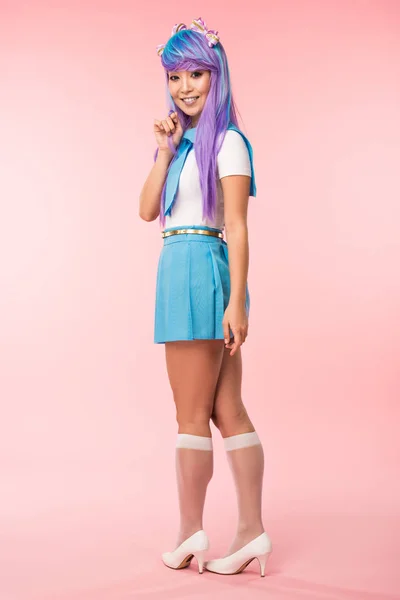 Full length view of otaku girl in purple wig smiling on pink — Stock Photo