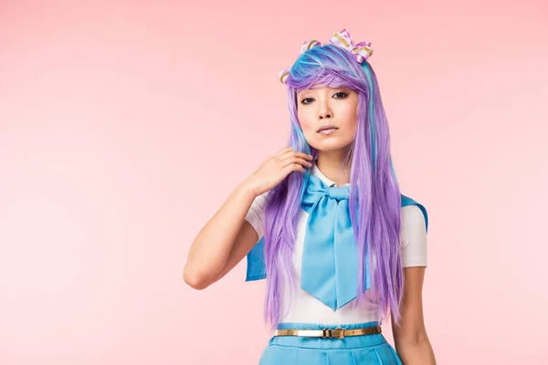 Bastante asiático anime chica en peluca mirando cámara en rosa - foto de stock