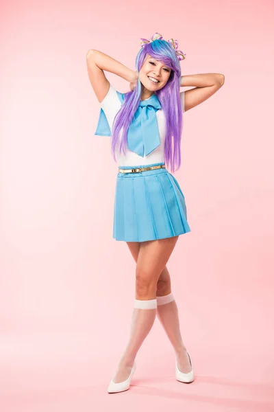 Full length view of otaku girl in purple wig smiling on pink — Stock Photo