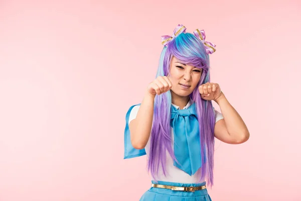 Irritado asiático anime chica en peluca posando aislado en rosa - foto de stock