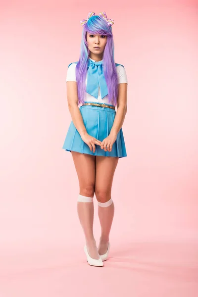 Full length view of sad asian anime girl in skirt standing on pink — Stock Photo