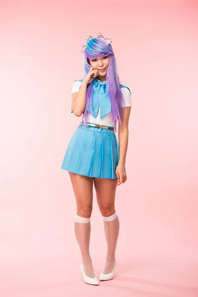 Vista completa de la chica otaku en peluca púrpura sonriendo en rosa - foto de stock