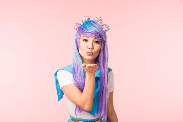 Asian anime girl in purple wig sending air kiss isolated on pink — Stock Photo