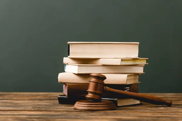 Stack of books and gavel on wooden surface isolated on grey — Stock Photo