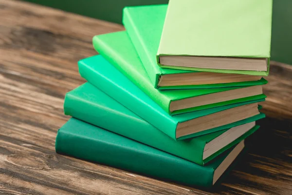 Stack of colorful books on wooden textured surface — Stock Photo