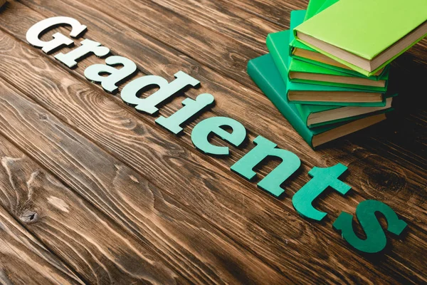 Livros verdes e letras na superfície texturizada de madeira — Fotografia de Stock